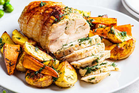 Stuffed chicken breast roll served with potato and sweet potato garnish on the festive table, close-up. Christmas recipe concept.の写真素材