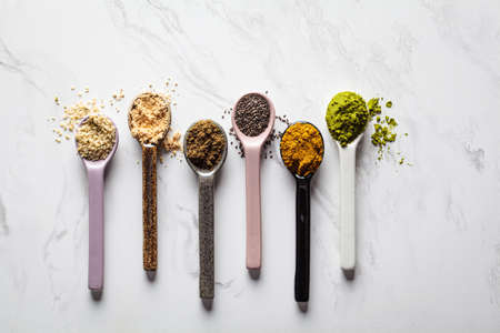 Super food powders in spoons, white marble background, copy space.の写真素材