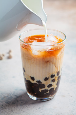 Cooking milk bubble tea with tapioca pearls in glass, gray background.の写真素材