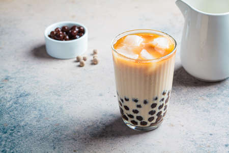 Milk bubble tea with tapioca pearls in a glass, gray background.の写真素材