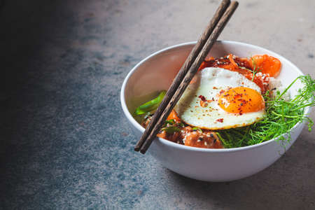Bibimbap - meat, rice, kimchi, egg and sprouts in a white bowl. Traditional Korean food.の写真素材