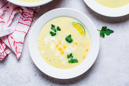 Plate of Mexican corn soup with cheese and herbs.の写真素材