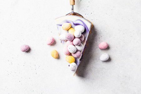 Easter dessert. Piece of berry cake decorated with Easter chocolate eggs, top view, copy space....