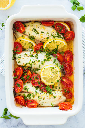 Baked cod fillet with cherry tomatoes and butter, top view. healthy diet recipe.