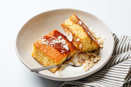 Citrus Israeli cake. Orange pound cake with yogurt, almonds and syrup, white background.