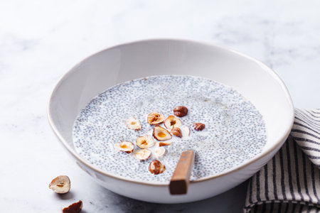 Chia pudding with hazelnuts and maple syrup, white background. Healthy vegan breakfast.の写真素材
