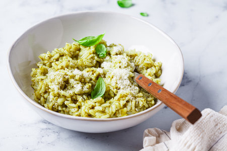Green pesto risotto with parmesan, white marble background.の写真素材