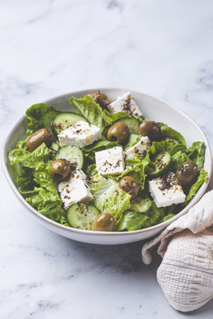 Green Greek salad with olives, feta cheese and cucumber, close-up.の写真素材