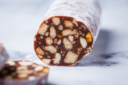 Chocolate salami with nuts on a white background. Traditional Italian sweet sausage for Easter.の写真素材