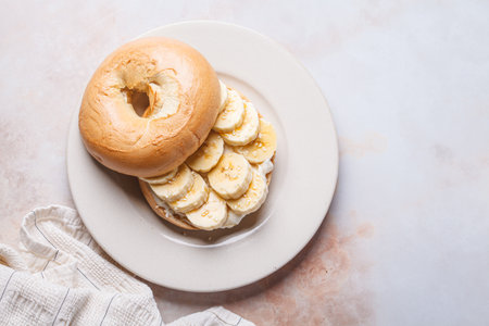 Breakfast bagels with cream cheese, banana and sesame seeds., top viewの写真素材