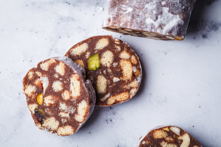 Chocolate salami with nuts on a white background. Traditional Italian sweet sausage for Easter.の写真素材