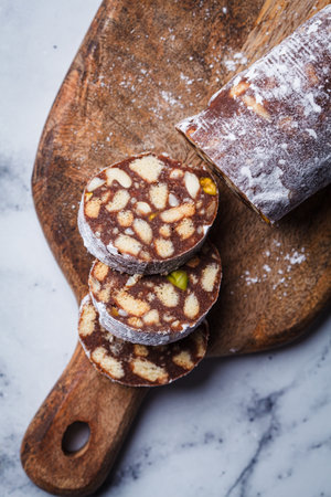 Chocolate salami with nuts on wooden board. Traditional Italian sweet sausage for Easter.の写真素材