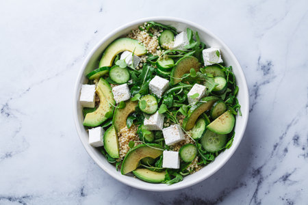 Green quinoa salad with cucumber, arugula, avocado and feta, top view.の写真素材