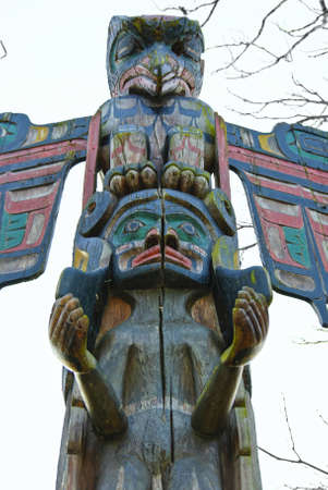 Totem pole outside on background of sky and trees brunchesの写真素材
