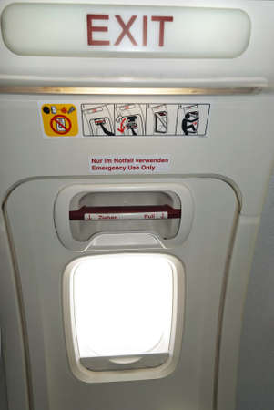 Emergency exit in the aircraft, text in English and German の写真素材