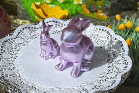 Pink Easter bunnies on the white plate, green decoration backgroundの写真素材