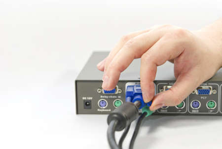 KVM  keyboard, video and mouse  switch and a human hand with an VGA  Video Graphics Array  connector...