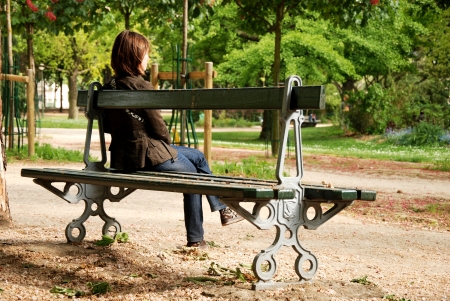 Beautiful young girl sitting on the benchのeditorial素材