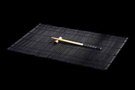 Japanese chopsticks on bamboo mat on black backgroundの写真素材