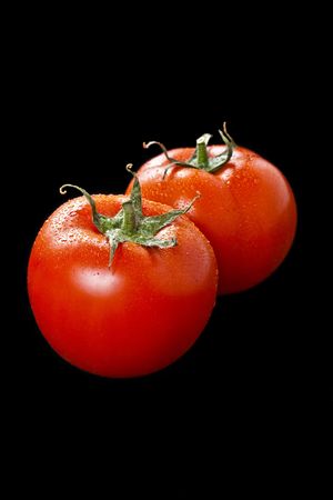 Two fresh tomatoes over blackの写真素材