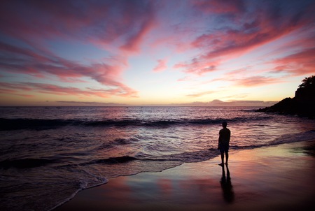 Silhouette of the man standing on the beach at sunset. Colorful skies. Orange horizon. Reflections in the ocean. Spain - Gran Canariaの写真素材