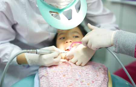 blur photo of dental tools work in kid mouthの写真素材