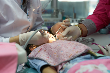 dentist repair kid teeth with assistant nurseの写真素材