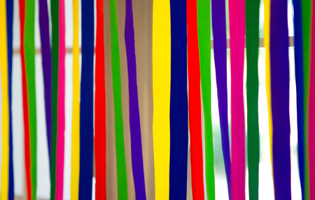 colourful paper stripes hang on window with natural light backgroundの写真素材