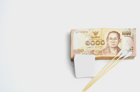 Money banknotes with gauze and cotton bud in health or accident or injury concept on isolated white background with copy text spaceの写真素材
