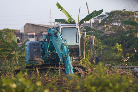 excavator tractor working on mud soil with treeの写真素材