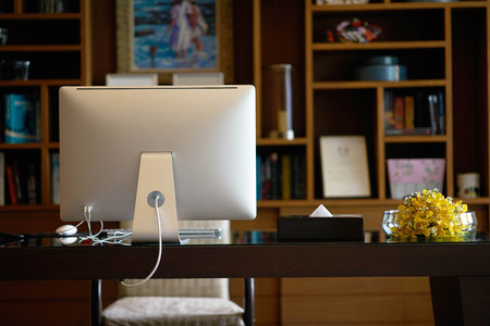 Work room with Table and behind view of computer desktopの写真素材