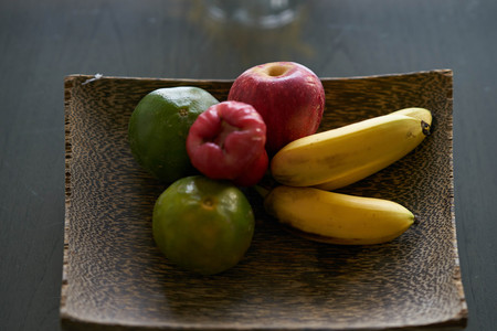 Fruit in wood tray (banana ,oranges,apple)の写真素材