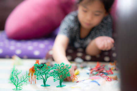 Girl lie down on cushion playing toyの写真素材