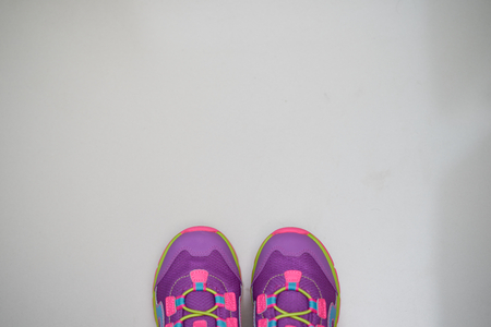 tip of pairs of kid shoes  on minimal  pastel color backgroundの写真素材
