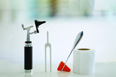 Tuning fork , Otoscope,tissue paper roll and hammer jerk on white floor ,top view with copy spaceの写真素材