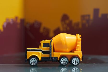 Yellow cement truck on blur city background,side viewの写真素材