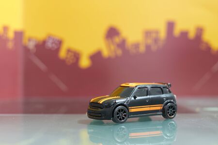 Black hatchback car toy selective focus on blur city backgroundの写真素材