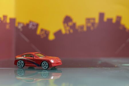 Red  Saloon car toy selective focus on blur city backgroundの写真素材