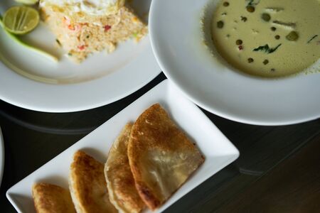 Thai chicken green curry with roti and fried rice on tableの写真素材