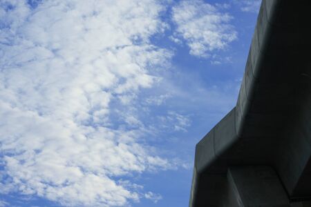 bottom view of overpass on blue sky clouds background