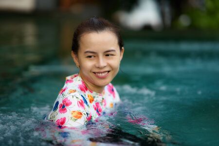 woman with goggles in pool water with smile in pool play portrait concept
