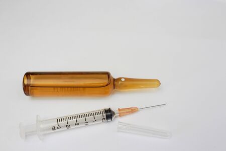 Medical syringe and drug ampule on white floor in overuse and abuse of addiction of illegal drugsの写真素材