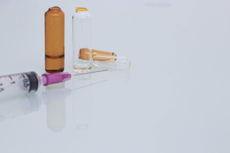 medical syringe and cracked ampule on clear backgroundの写真素材