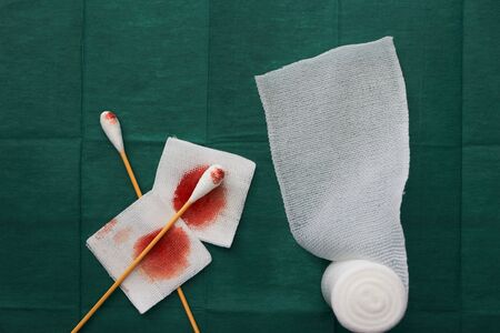 tools include swab,blood gauze and roll gauze on green surgical dress  for clean woundの写真素材