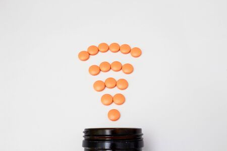 Orange coated round drug tablets on drugstore and bottle in communicated worldwide distribution wifi connected business medical pharmaceutical seller conceptの写真素材