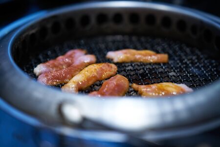 Raw meat grilling in grating firewood oven in asian restaurant,side viewの写真素材