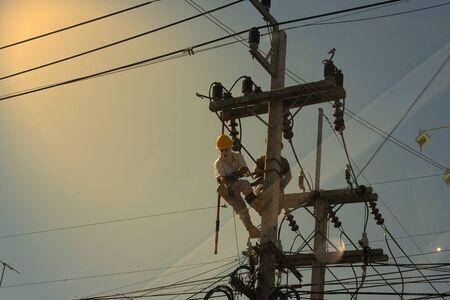 technician work on high voltage electicity pole with copy space and reflect lightの写真素材