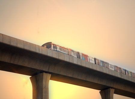 moving blur of sky train on fly over track with sun lightの写真素材