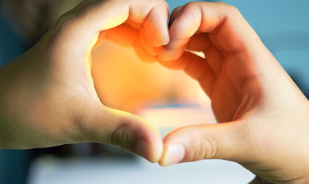 Hands do heart or love sign with sun flare for valentine