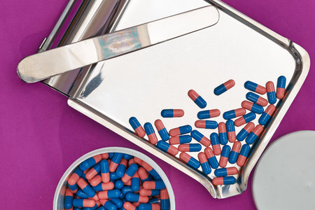blue capsules on tray with jar in pharmacy shop on purple backgroundの写真素材